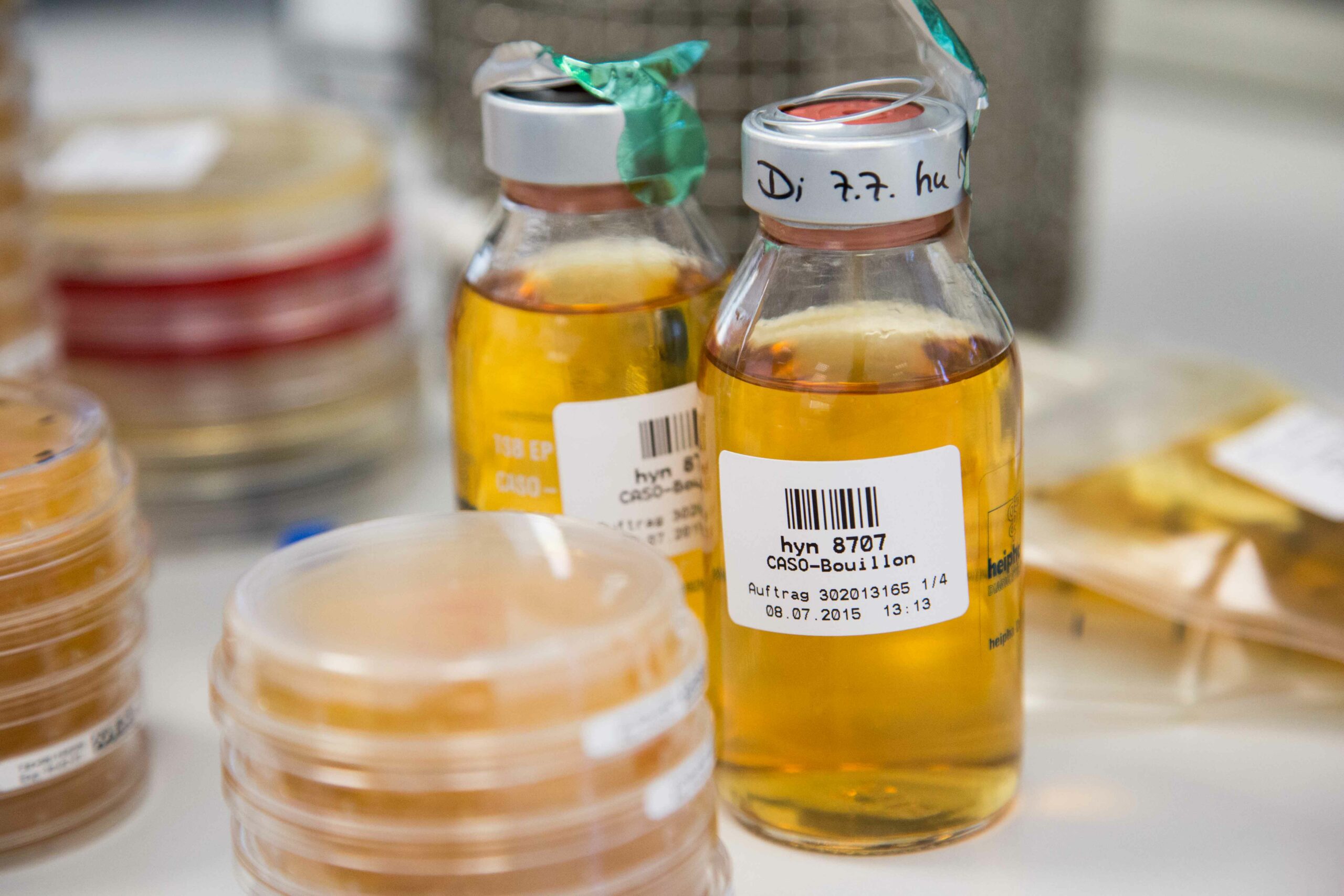 zwei Flaschen aus der Pharma-Industrie mit verschiedenen Proben im Vordergrund